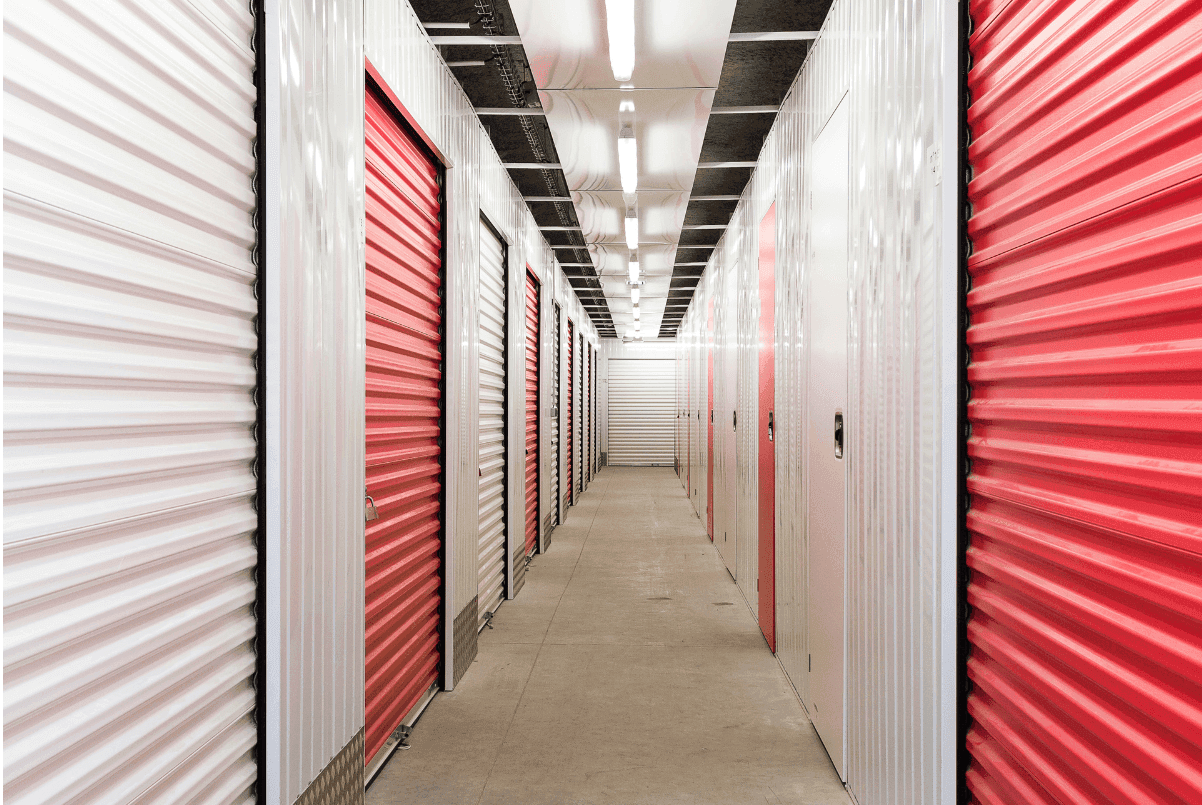 Couloir de box de stockage du centre HOMEBOX Ajaccio-Centre avec portes roulantes rouges et blanches.